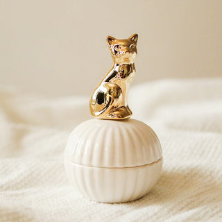 Die Hilma Schmuckdose mit einem goldenen Katzen-Design und einer Muschelform. Diese praktische und elegante Dose ist ideal zur Aufbewahrung von Schmuck oder kleinen Accessoires. Der glänzende goldene Kater auf dem Deckel verleiht der Dose einen einzigartigen, stilvollen Look, der in jedem Raum ein echter Hingucker ist. Perfekt für das Schlafzimmer oder als dekoratives Element auf dem Schminktisch.