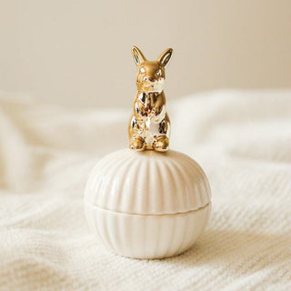 Die Hilma Schmuckdose mit einem goldenen Hasen-Design und einer Muschelform. Diese elegante Schmuckdose bietet eine praktische Aufbewahrungsmöglichkeit für Schmuck oder kleine Gegenstände. Der goldene Hase auf dem Deckel verleiht der Dose einen charmanten und verspielten Look. Ideal als dekoratives Element für Ihr Zuhause, das sowohl Funktionalität als auch Stil vereint.