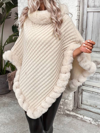 Eine Frau trägt einen eleganten, cremefarbenen Kapuzenpullover mit einem weichen, flauschigen Kragen und einer zarten Struktur. Der Pullover ist mit einem flauschigen Rand an den Ärmeln und dem Saum verziert, was ihm ein luxuriöses und gemütliches Aussehen verleiht. Sie kombiniert ihn mit schwarzen Leggings und einer handtasche, was den sportlichen und dennoch stylischen Look unterstreicht.