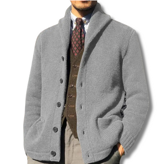 Liora Chique Vest in stilvollem Grau für Herren. Das elegante Strickdesign mit Knopfleiste und hohem Kragen verleiht einen zeitlosen Look, perfekt für formelle Anlässe oder gehobene Freizeitkleidung.