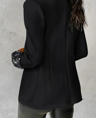 Luxora Blazer in Schwarz, mit glitzernden Details an den Ärmeln. Die Rückansicht zeigt den fließenden Schnitt des Blazers, der eine elegante und moderne Passform bietet, ideal für vielseitige Anlässe.