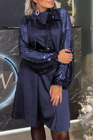 Lyria elegantes Kleid in tiefem Blau, verziert mit funkelnden Pailletten an den Ärmelabschlüssen. Das klassische Design ist perfekt für festliche Anlässe und verleiht einen stilvollen Look.