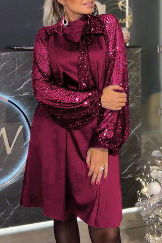 Lyria elegantes Kleid in einem tiefen Rotton, glänzend und verziert mit funkelnden Pailletten an den Ärmeln. Das klassische Design und die elegante Silhouette machen es ideal für festliche Anlässe.