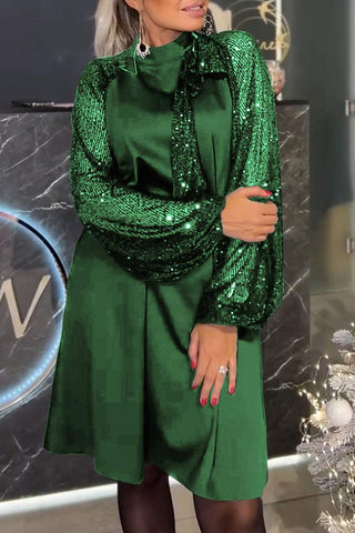 Lyria elegantes Kleid in einem tiefen Grünton, glänzend und verziert mit funkelnden Pailletten an den Ärmeln. Das klassische Design mit einem eleganten Schnitt macht es zu einer stilvollen Wahl für besondere Anlässe.