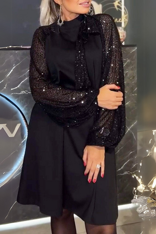 Lyria elegantes schwarzes Kleid mit funkelnden Pailletten an den langen, transparenten Ärmeln. Der klassische, schlichte Schnitt und die edle Verarbeitung machen es zur perfekten Wahl für elegante Anlässe.