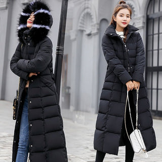 Das Bild zeigt zwei Frauen, die einen langen, schwarzen Wintermantel mit einem voluminösen Pelzkragen tragen. Beide Mäntel sind gepolstert, bieten einen hohen Wärmekomfort und einen modernen, winterlichen Stil. Die Frau auf der linken Seite hat den Kragen hochgeklappt, um zusätzlichen Schutz vor der Kälte zu bieten, während die andere Frau den Kragen offen trägt. Beide Frauen tragen den Mantel in einer urbanen Umgebung, perfekt für kaltes Wetter. 
