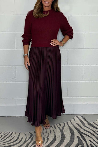 Urbana Plissierter Rock in edlem Weinrot mit fließendem Faltenwurf. Kombiniert mit einem farblich abgestimmten Strickpullover für einen eleganten und modernen Look. Ideal für besondere Anlässe oder stilvolle Alltagsmomente.