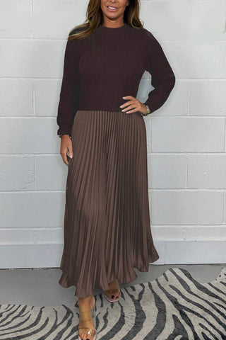 Urbana Plissierter Rock in stilvollem Braunton mit elegantem Faltenwurf, kombiniert mit einem schlichten, dunkelbraunen Strickpullover. Der Look strahlt schlichte Eleganz und zeitlose Mode für besondere Anlässe und den modernen Alltag aus.